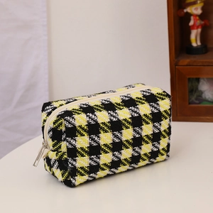 Detail of yellow and black checkered knit fabric texture on this large makeup pouch
