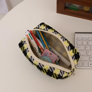 Detailed close-up of tweed plaid makeup bag showing large capacity and zipper texture