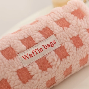 Detail of pink waffle fleece fabric texture and Waffle Bags woven label on the pouch