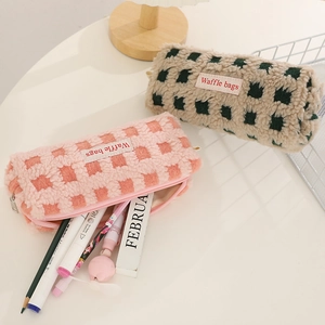 Top view of waffle textured plush pencil bags in pastel colors with zipper closure