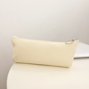 Dettaglio ravvicinato dell'astuccio in tela beige con cerniera ad anello in metallo di qualità