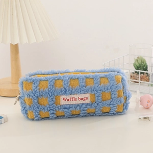 Detailed view of the soft waffle texture and fabric label on the blue and yellow pencil case