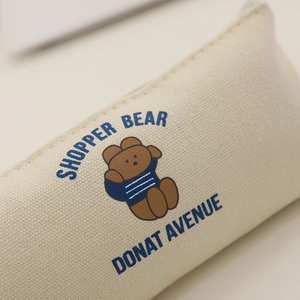 Dettaglio della trama in tela e della stampa dell'orso su questo astuccio portapenne