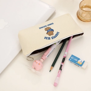Astuccio in tela minimalista con illustrazione di orso su una scrivania con accessori