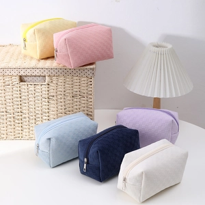 Checkboard high-capacity pencil cases in various pastel colors on a white table