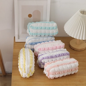 Colorful bubble pleated macaron pencil cases set in a cozy home setting with warm lighting