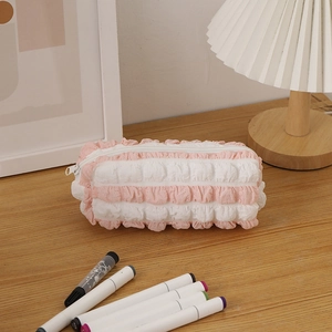 Close-up of pink and white seersucker pencil case with pleated texture and zipper