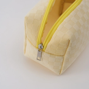 Detail of a large-capacity checkered pencil case with smooth silver metal zipper finish
