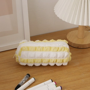 Macro detail of puffy yellow and white striped pencil case with soft bubble texture