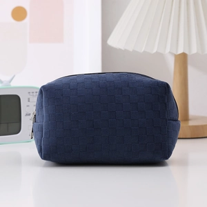 Detail of navy blue checkered woven pencil case with silver zipper in a lifestyle setting