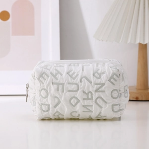 Close-up of white quilted puffer canvas bag with letter texture and zipper closure
