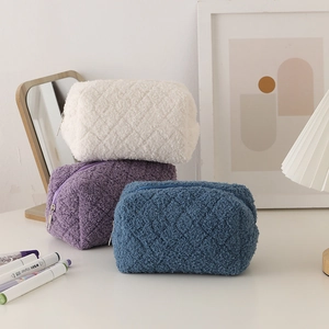 Detailed view of plush quilted pencil cases in white, purple, and blue colors