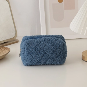 Macro detail of dark blue sherpa fleece texture and smooth zipper on plush stationery bag