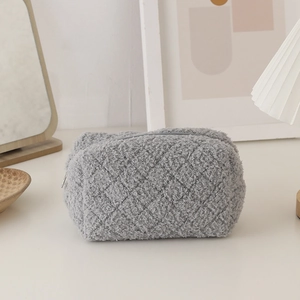 Macro shot of grey teddy plush stationery bag with quilted diamond pattern and metal zipper