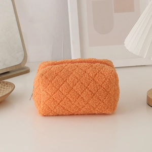 Macro detail of plush orange faux fur stationery bag with classic quilted diamond pattern