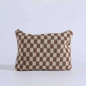 Detail of soft knit checkered makeup bag with brown weave texture and zip closure
