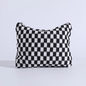 Detail view of the soft knitted checkered makeup bag with durable silver metal zipper