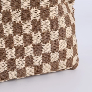 Close-up of the checkerboard knit texture and stitching on the brown cosmetic bag