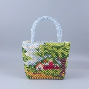 Macro view of a handmade beaded handbag featuring a colorful country landscape scenery