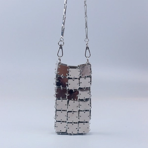 Macro shot of futuristic silver metallic square mirror plates and chain strap on crossbody bag
