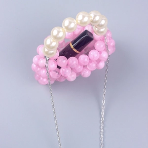Detail of pink acrylic bead bag with white pearl handle and silver chain strap