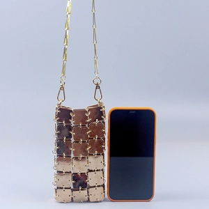 Detail of gold metal sequin mini phone bag showing square plates and orange phone for scale