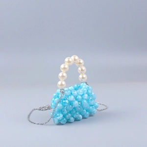 Detail of light blue beaded handbag with white pearl handle and silver metal chain