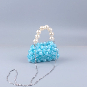 Detailed view of light blue acrylic beads and white pearl handle on mini crossbody bag