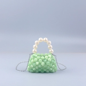 Detail of green marbled beads and white pearls on a mini crossbody handbag with silver chain