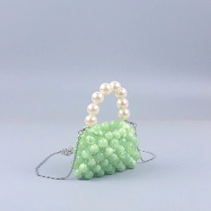 Detail of light green beaded handbag with large pearl handle and silver chain strap