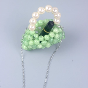Detail of mini light green acrylic beaded bag with pearl handle and silver chain strap