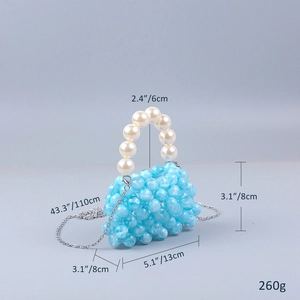 Macro shot of blue acrylic beads and white pearl handle of a handmade mini bag