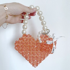 Handmade amber heart-shaped beaded handbag with pearl handle and ribbon detail
