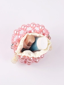 Top view of pink handmade beaded bucket bag showing satin drawstring pouch and cosmetics
