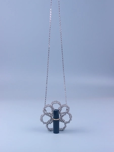 Detailed view of silver beaded flower mini bag holding a black lipstick for size