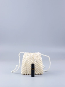 Détail macro du sac perle fait main avec rouge à lèvres pour comparer la taille