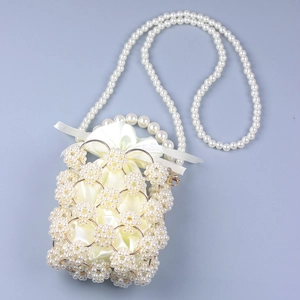 Detail view of woven pearl bucket bag with gold metal rings and satin inner pouch