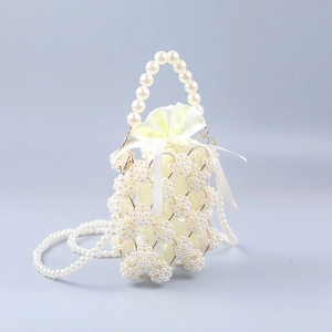 Detail of handmade pearl bucket bag featuring satin drawstring pouch and metal rings