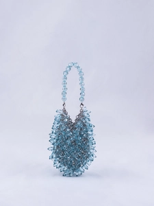 Close-up of light blue teardrop beads and radiant acrylic crystal texture on handbag
