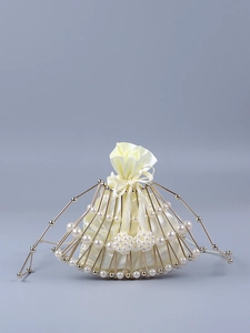 Macro detail of fan-shaped pearl bag featuring gold metal frame and satin drawstring pouch