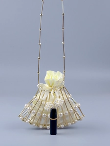 Detail of fan-shaped beaded bag with gold metal bars, pearls, and a satin drawstring pouch