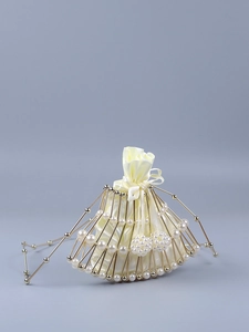 Detail of beaded fan bag showing golden metal frame and cream satin drawstring pouch