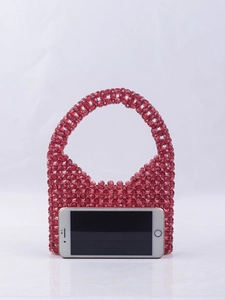 Detailed view of red acrylic beaded handbag with smartphone inside showing storage capacity