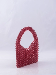 Close-up of handmade beaded handbag featuring translucent red acrylic round beads