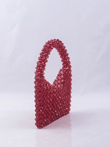 Detailed view of red handmade woven acrylic bead handbag with triangular geometric shape