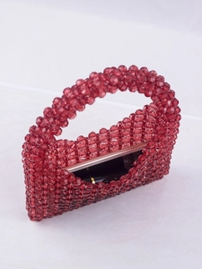 Close-up of red beaded handbag interior showing phone and lipstick storage space
