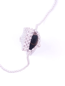 Macro view of a handmade pearl beaded star mini bag showing lipstick storage detail