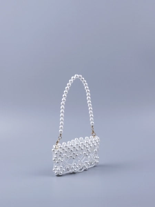 Detail of handmade white pearl beaded handbag with golden metal lobster clasps