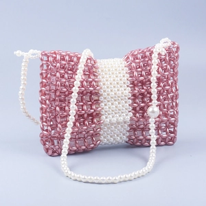 Détail d'un sac de soirée fait main en perles roses et blanches avec nœud papillon