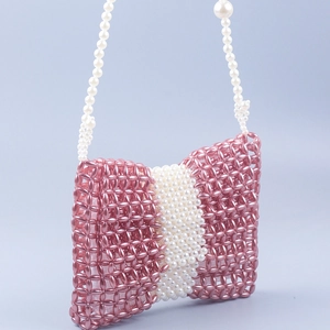 Gros plan détaillé d'un sac à main en perles roses et blanches avec nœud papillon